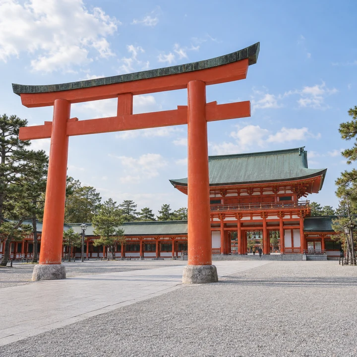 開けた境内に立つ大きな朱塗りの鳥居と、青空を背にした壮麗な社殿